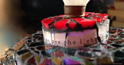 Picture of glass mosaic on wood detail with text that says: we are the light of the world under glass and iridescent glass 