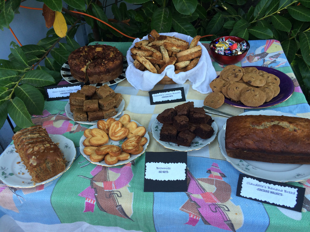 photo of various desserts on a polish tablecloth at our birthday party - assunta's bicotti, claudette's banana bread, palm leaves chocolate chip cookies, blondies and brownies and sour cream coffee cake