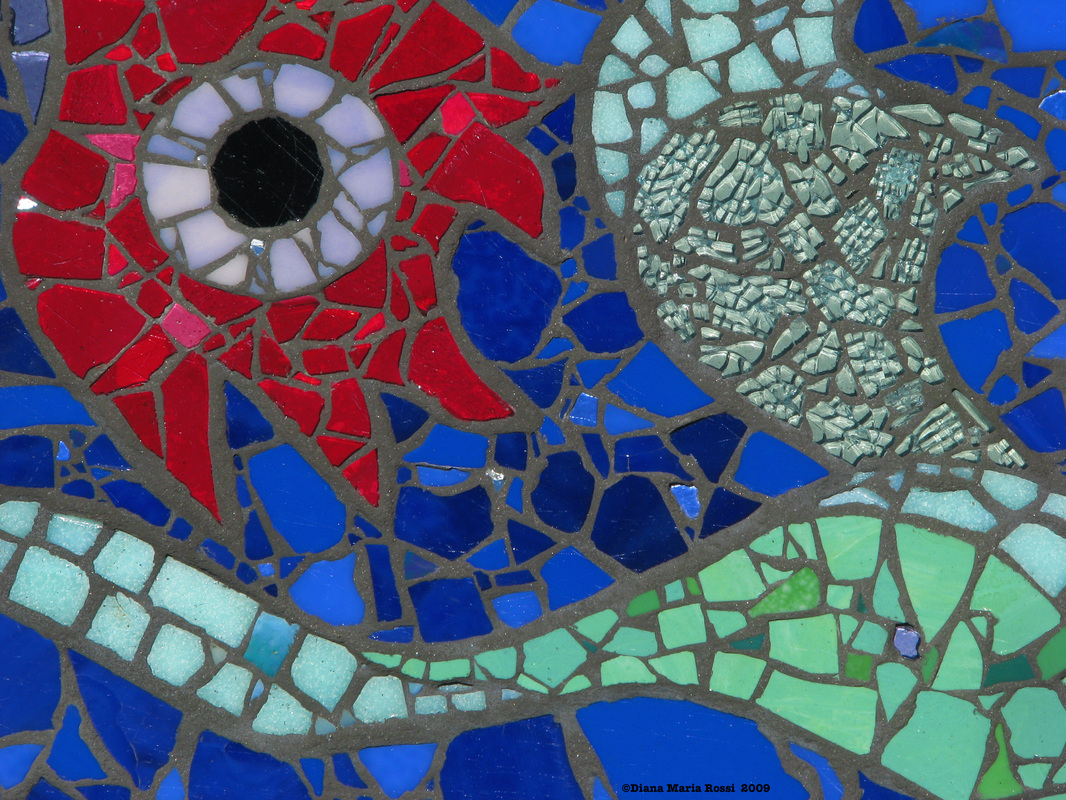 Picture of art glass mosaic on cement board detail of flower with eye which is red and green tendrils on cobalt blue background