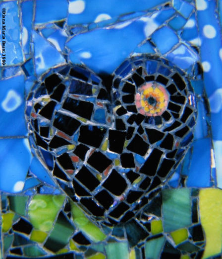 Picture of art glass mosaic on wood heart with circle and blue background and green foreground