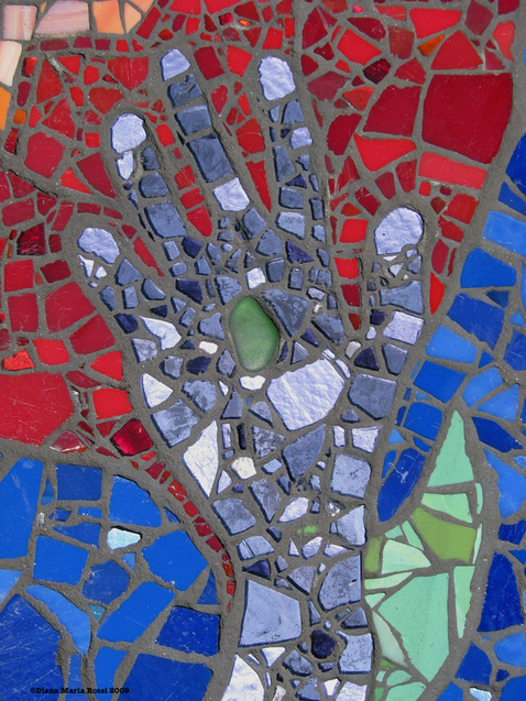 Picture of art glass mosaic on wood detail of purple hand with red and blue background