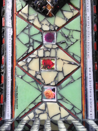 photo of glass mosaic, this is a detail and includes the background section which is cream colored and minty green. The cream and green are in a diamond pattern similar to the Jacob's Ladder string game. There are three photographs of roses set into the diamonds or between them.