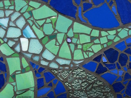 Picture of art glass mosaic on cement board detail green leaves and smashed auto glass on cobalt blue background