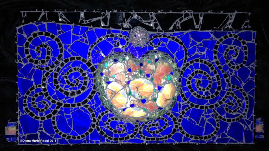 photo of glass heart/ the heart is made of transparent glass over photos of  orange/yellow roses that shine through/ there are flecks of cobalt and intense green interspersed throughout the heart. the background is cobalt blue with swirls of black and there is a pinkish orb above the heart