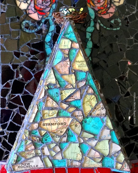 photo of a glass mosaic on wood, triangle shaped, clear glass over a map