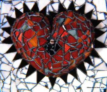 Picture of art glass mosaic on wood orange heart with black spokes on white background